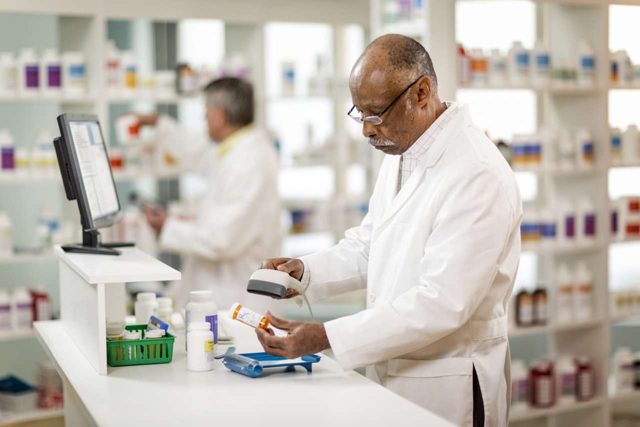pharmacist scans pill bottles at a pharmacy