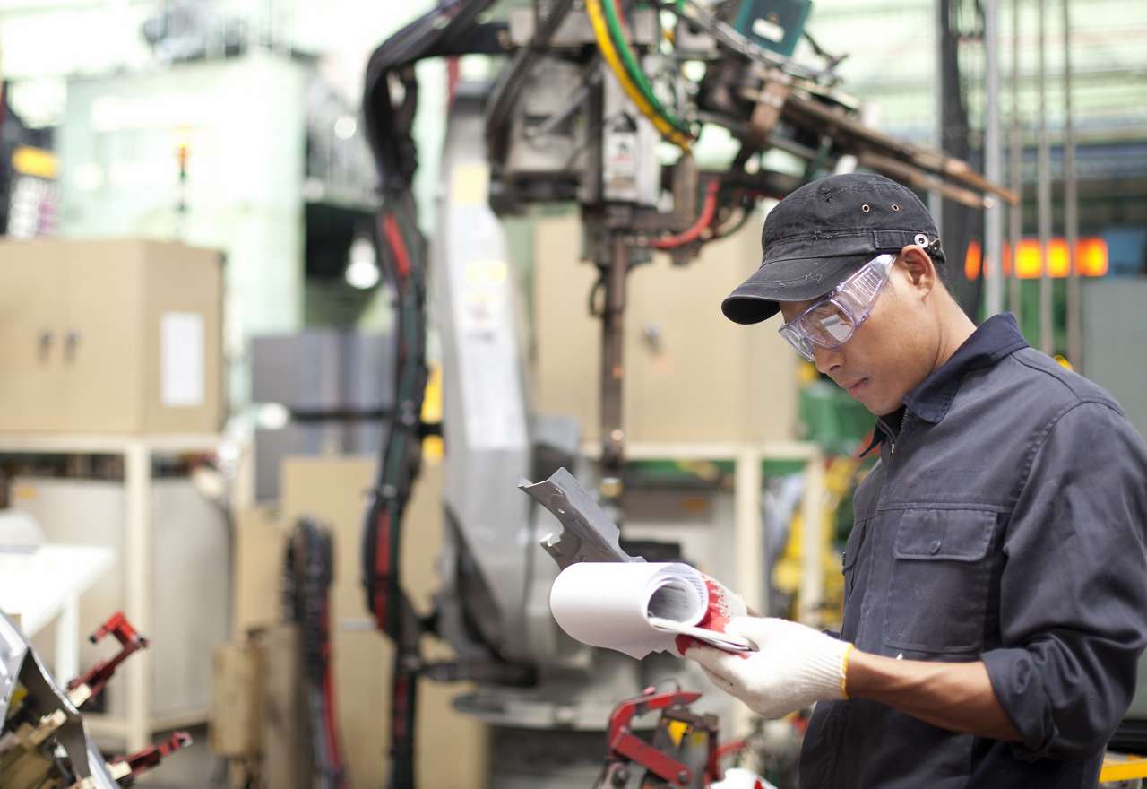 man looking at clipboard in engineering warehouse